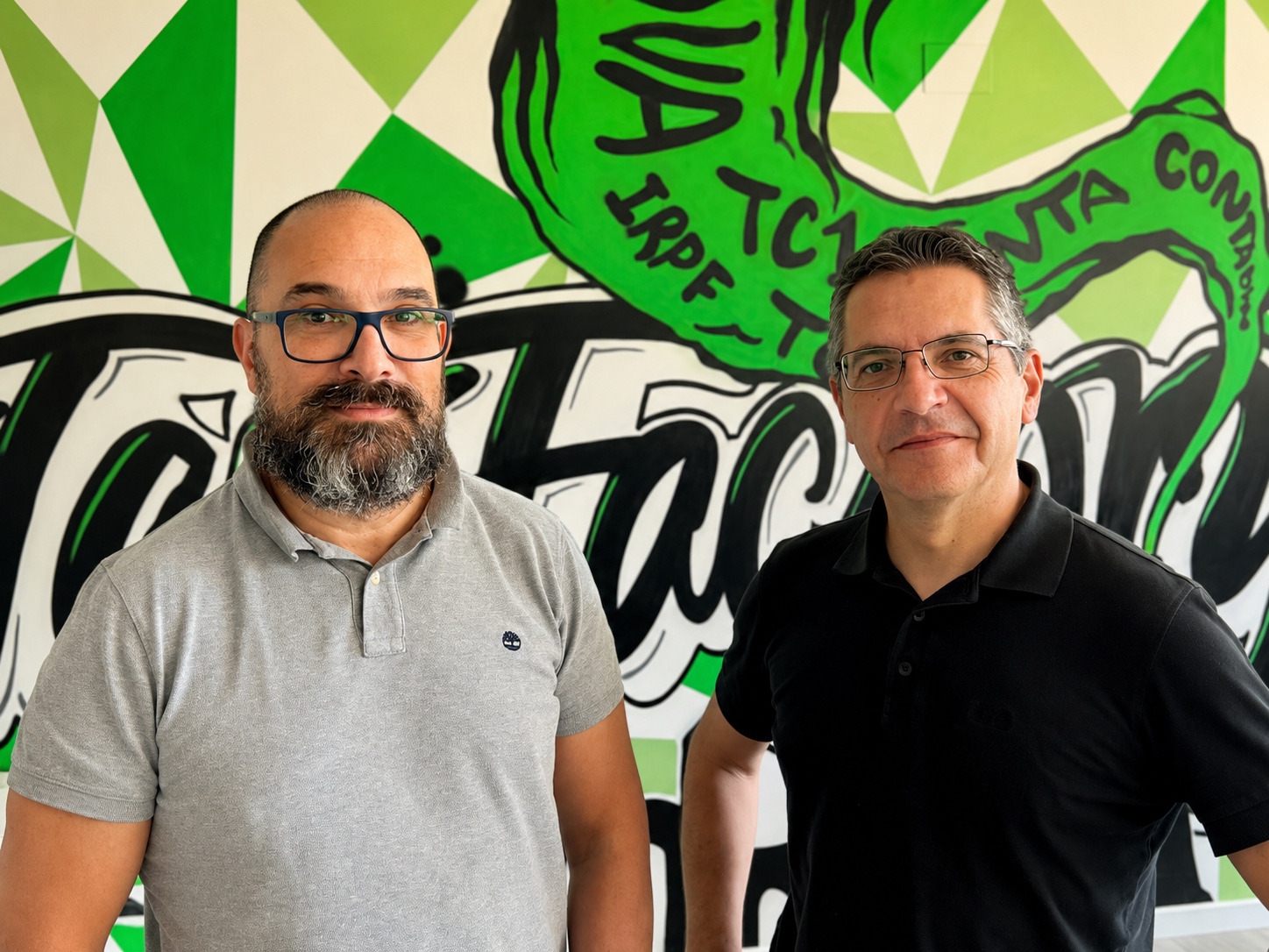 Guillem Márquez y Luis López frente al mural verde de TaxFactory